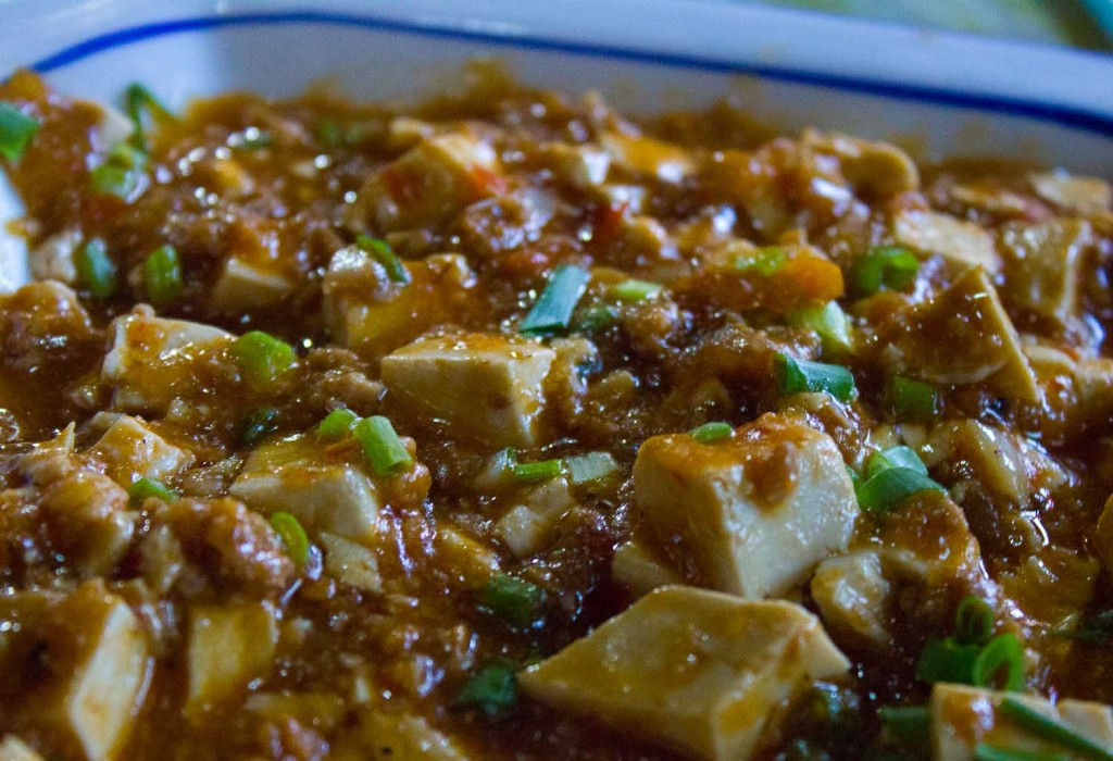 Mapo doufu, a Sichuan tofu dish, garnished with spring onions.
