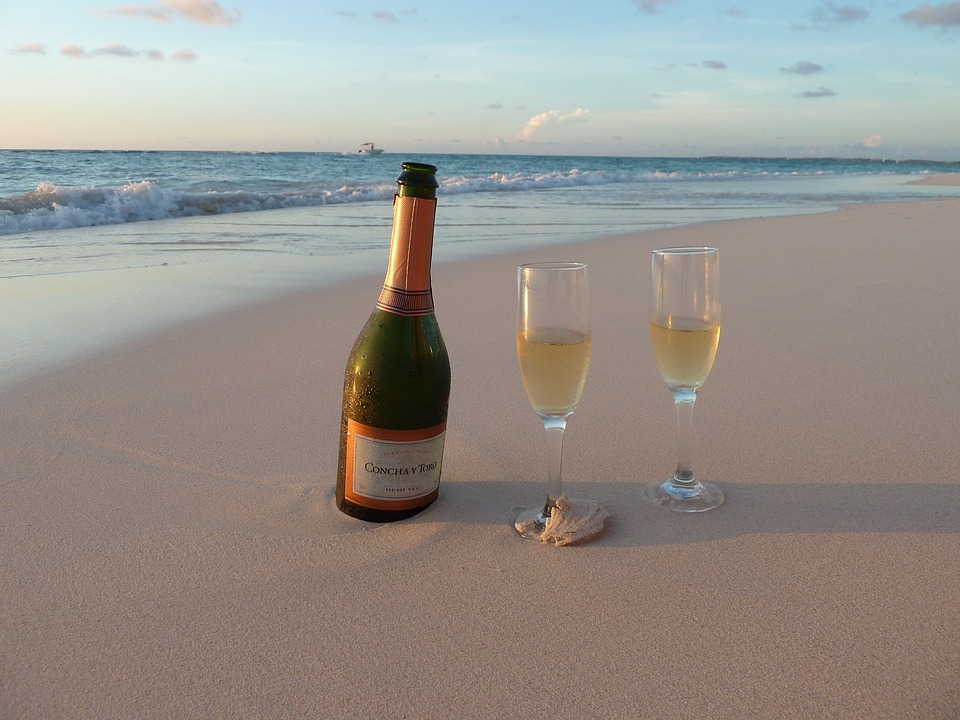 Champagne and glasses on the sand.