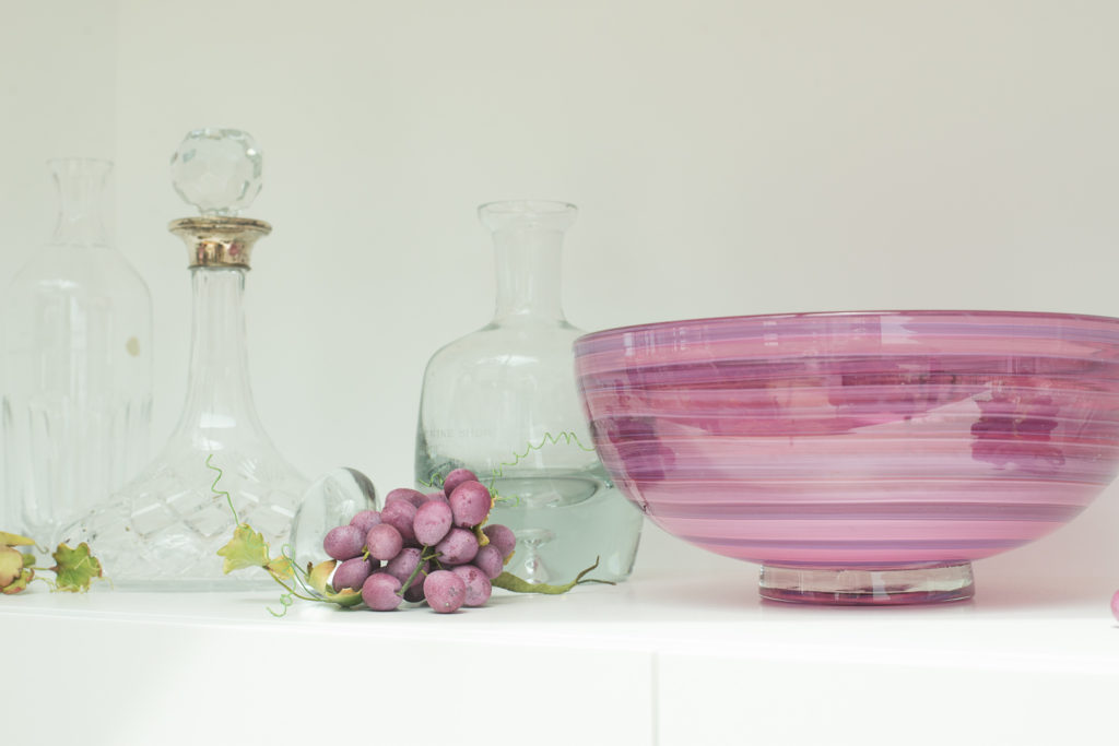 Bowl, decanters and sculpted grapes in the tasting room.