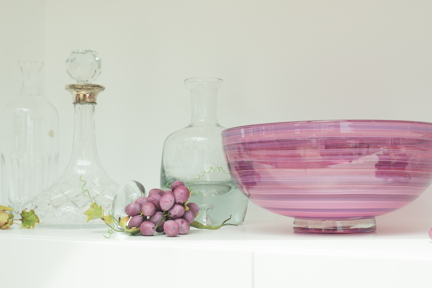 Bowl, decanters and sculpted grapes in the tasting room.