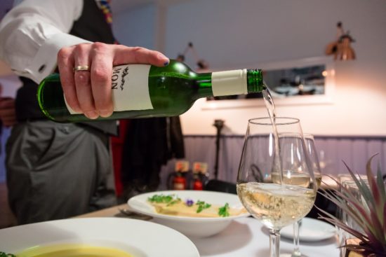 Pouring wine over dinner